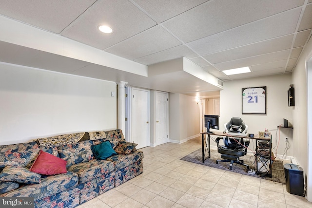 home office with a paneled ceiling, light tile patterned floors, and baseboards