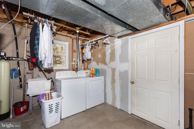 clothes washing area with a sink, laundry area, and washing machine and dryer