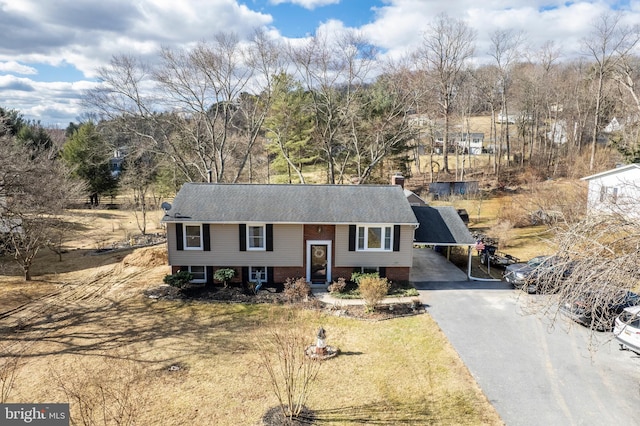 bi-level home featuring driveway and brick siding