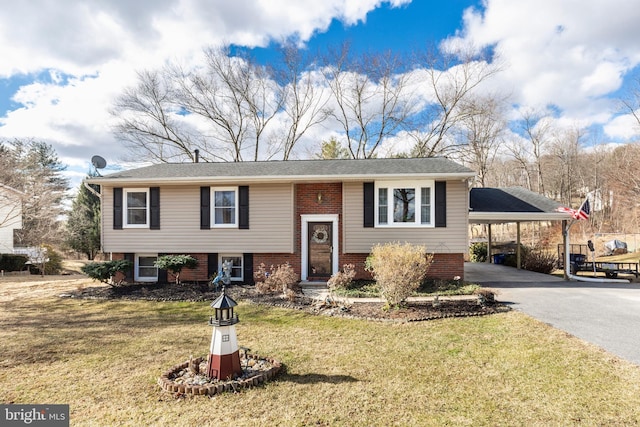 bi-level home featuring driveway, a carport, a front yard, and brick siding