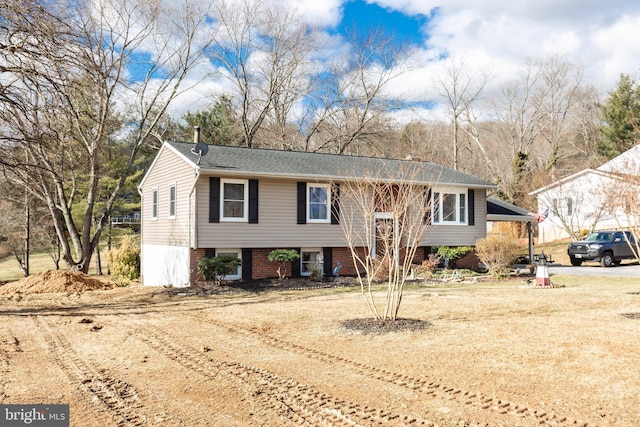 bi-level home featuring driveway and brick siding