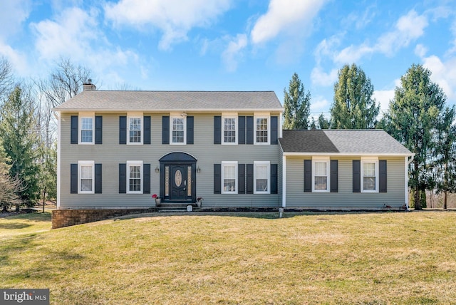 colonial-style house with a front yard and a chimney