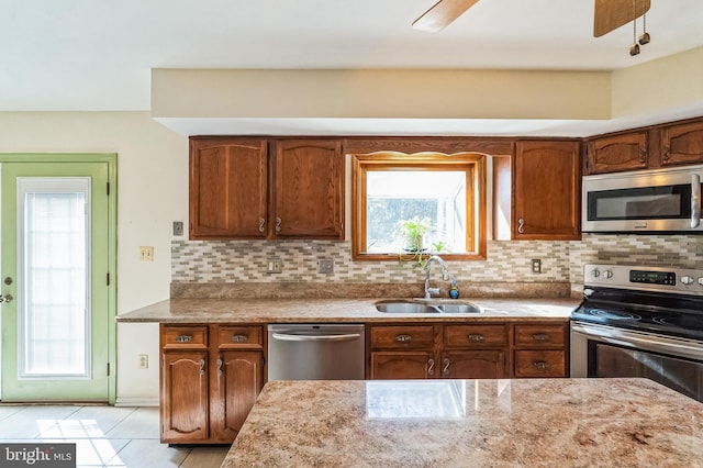 kitchen with tasteful backsplash, stainless steel appliances, ceiling fan, and a sink