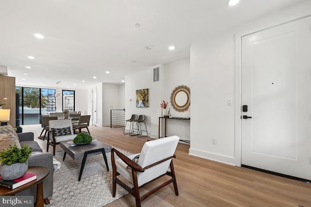 living area featuring light wood-style floors, baseboards, visible vents, and recessed lighting