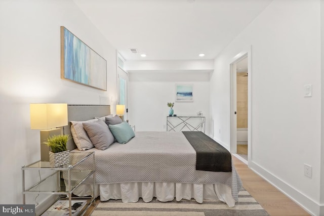 bedroom featuring visible vents, baseboards, connected bathroom, wood finished floors, and recessed lighting