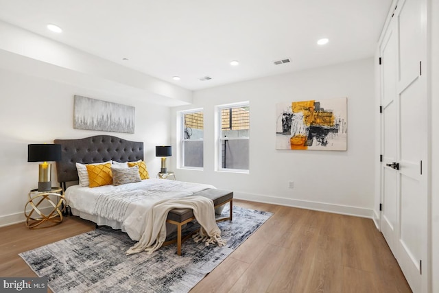 bedroom featuring baseboards, wood finished floors, and recessed lighting