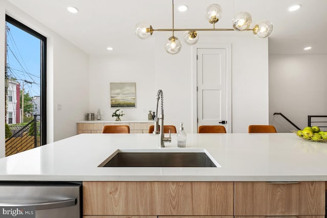 kitchen with dishwasher, light countertops, a sink, and recessed lighting