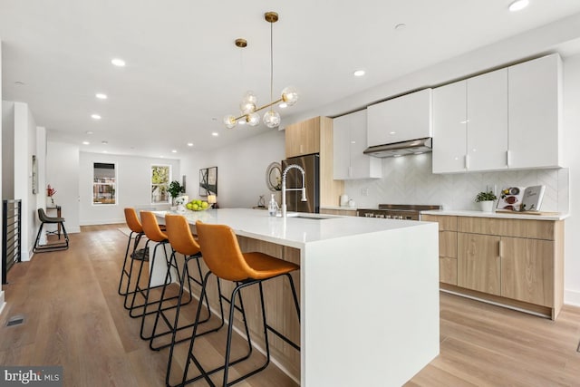 kitchen with modern cabinets, a sink, and a kitchen breakfast bar