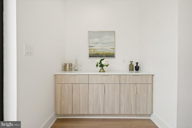 bar featuring baseboards and wood finished floors