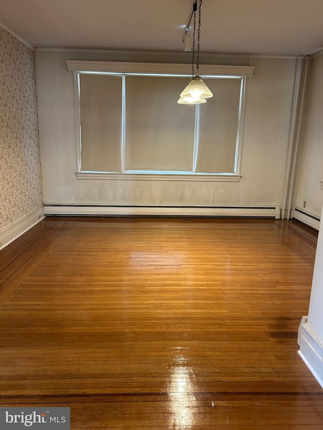 unfurnished room with wallpapered walls, a baseboard radiator, baseboard heating, and wood finished floors