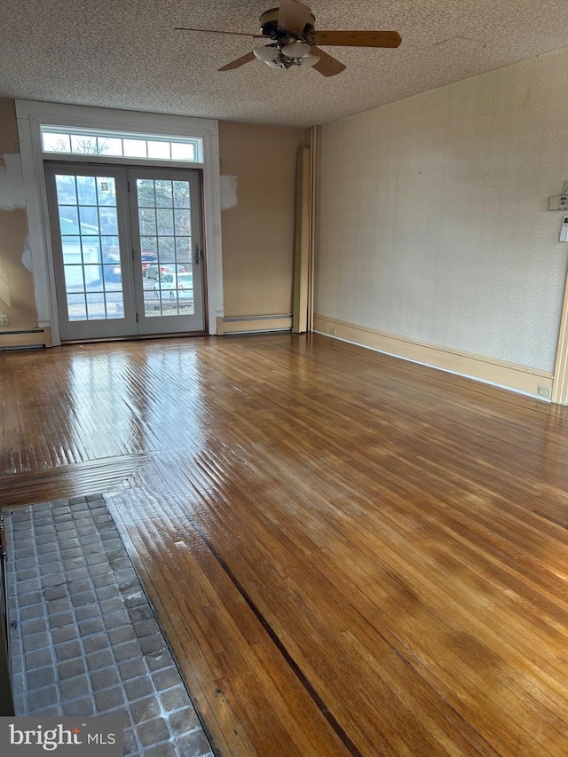 spare room with hardwood / wood-style flooring, baseboards, baseboard heating, and a textured ceiling