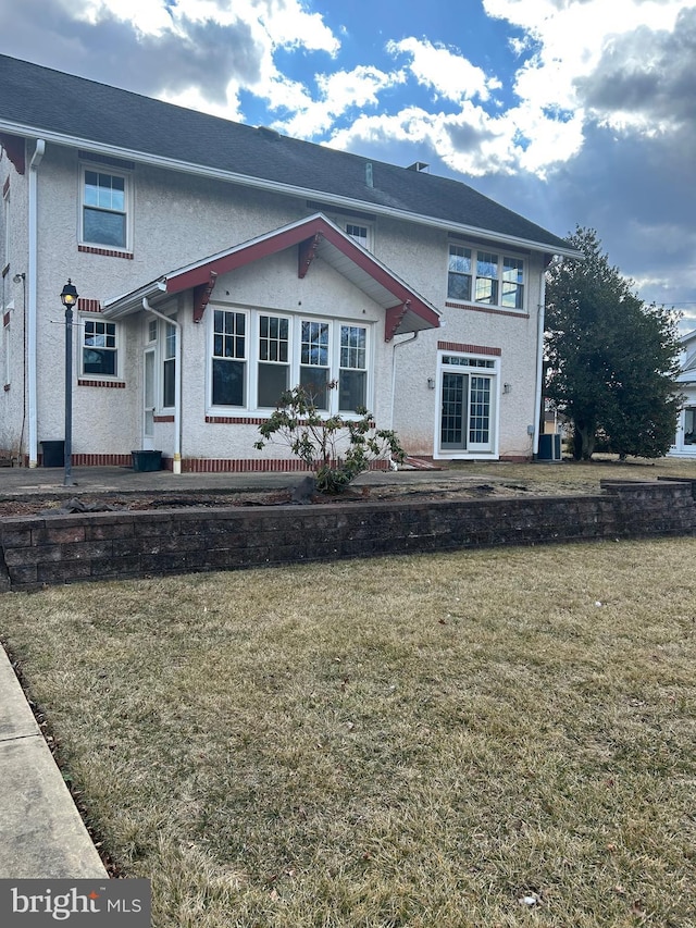 view of front of home with a front yard and stucco siding