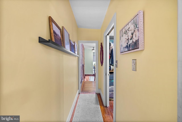 hallway with wood finished floors and baseboards