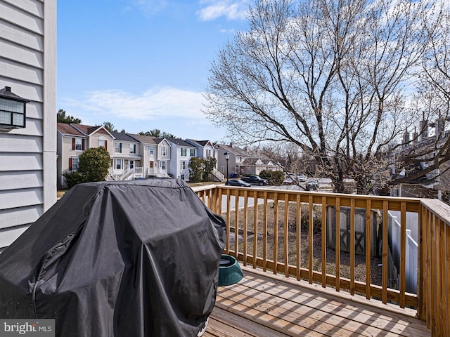 wooden deck with a residential view and a grill