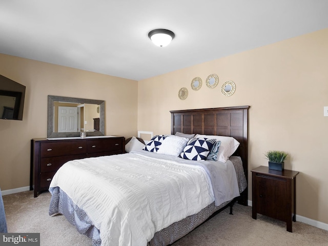 bedroom with baseboards and light colored carpet