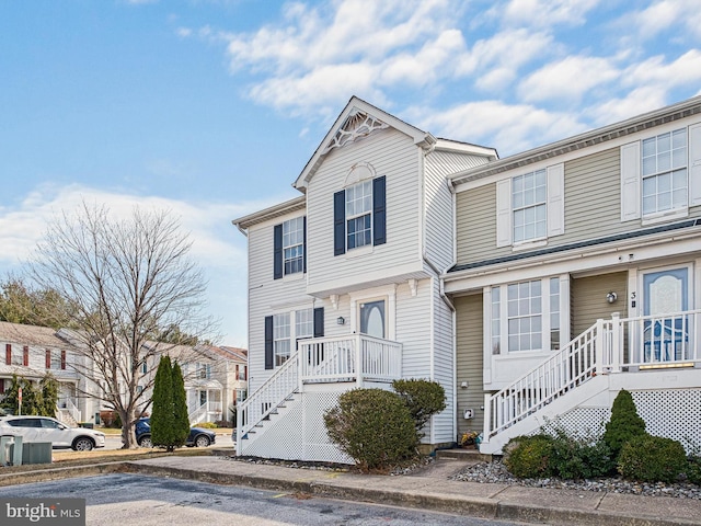 multi unit property with stairs, a porch, and a residential view