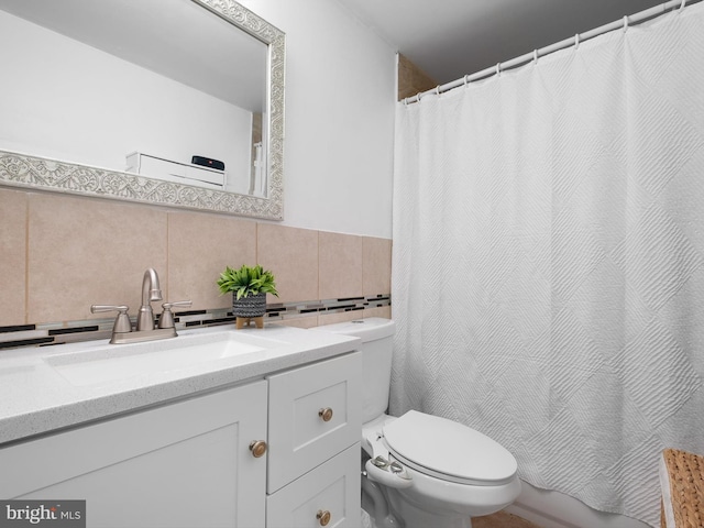 full bathroom with curtained shower, vanity, toilet, and tile walls