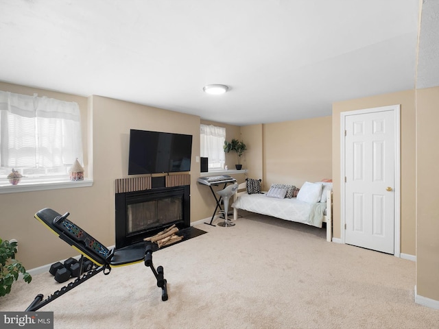 bedroom with baseboards, a fireplace with flush hearth, and carpet