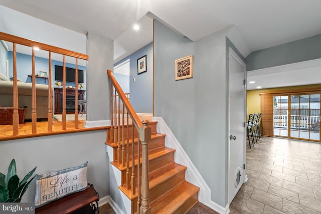 staircase featuring recessed lighting, stone finish flooring, and baseboards