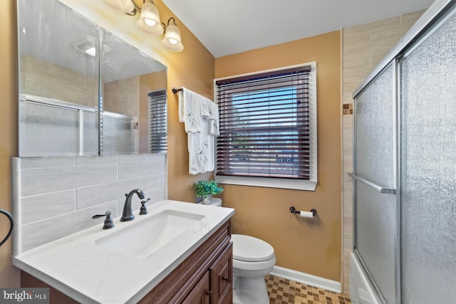 bathroom with toilet, vanity, baseboards, tasteful backsplash, and a shower with door