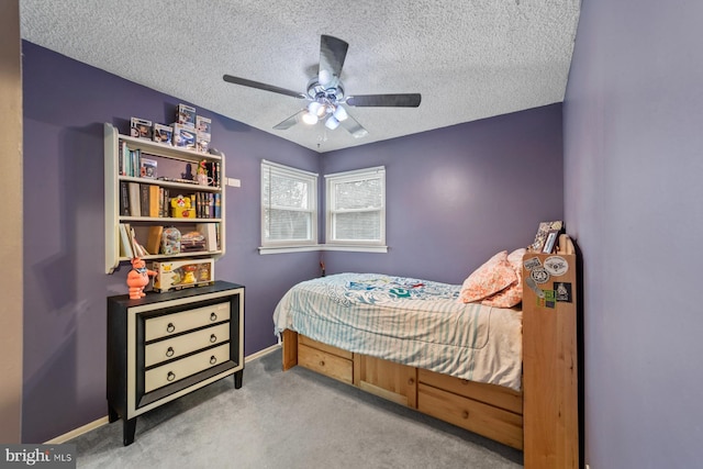 carpeted bedroom with ceiling fan, a textured ceiling, and baseboards