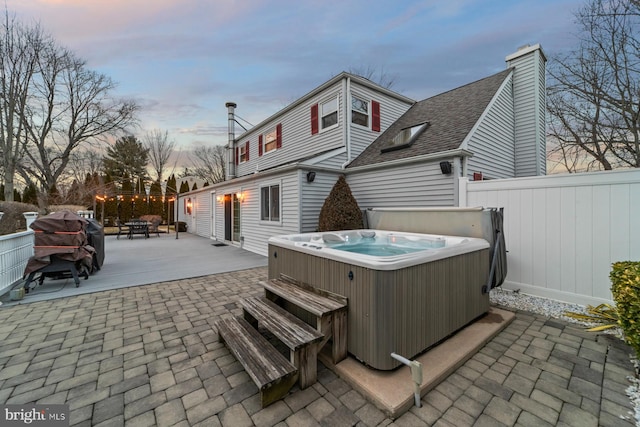 exterior space with fence and a hot tub