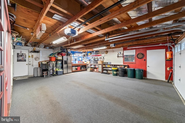 garage featuring a garage door opener, stainless steel fridge, and a workshop area