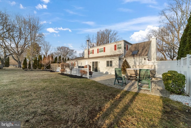 rear view of house featuring a shingled roof, a fenced backyard, a patio, and a lawn