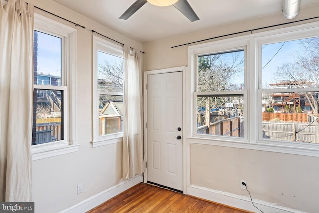 doorway to outside featuring plenty of natural light, baseboards, ceiling fan, and wood finished floors