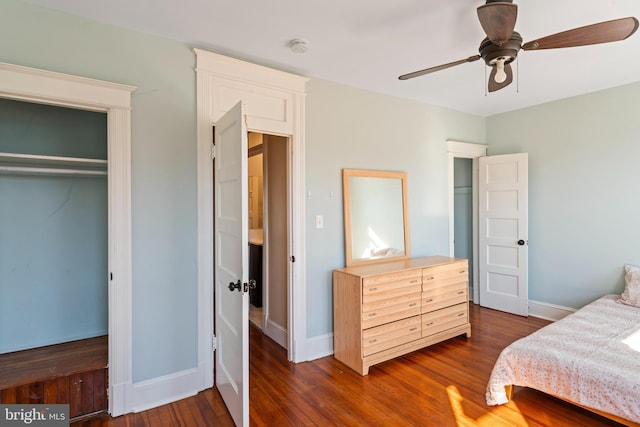 bedroom with a closet, dark wood finished floors, baseboards, and ceiling fan