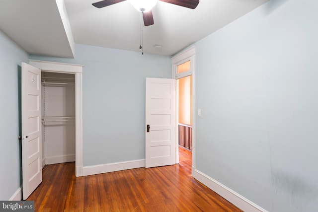 unfurnished bedroom with ceiling fan, a closet, wood finished floors, and baseboards