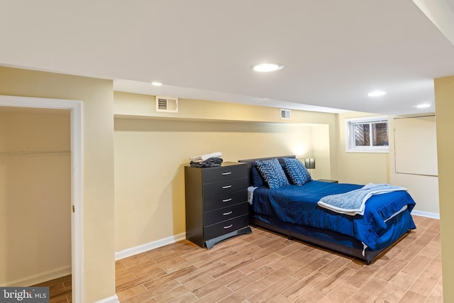 bedroom with light wood finished floors, recessed lighting, visible vents, and baseboards