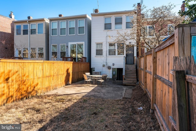 back of house featuring a fenced backyard and a patio