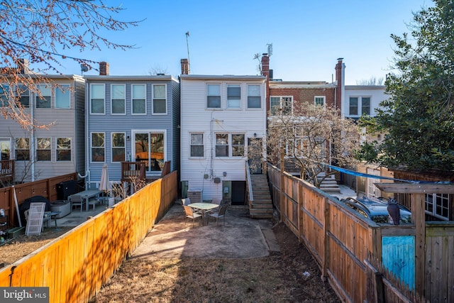 rear view of property with fence, stairway, and a patio