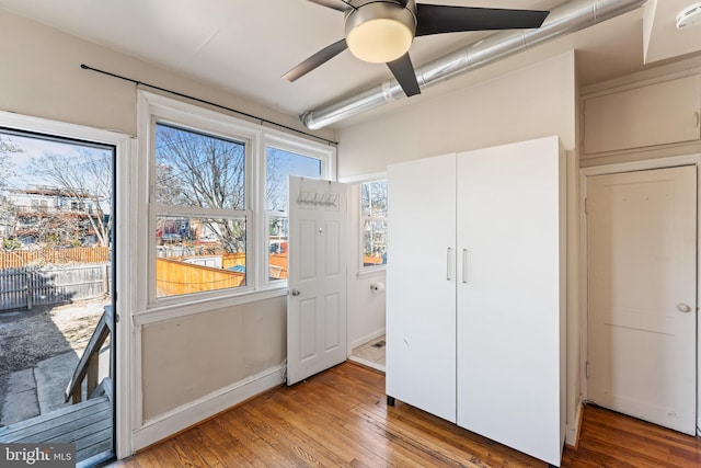 unfurnished bedroom featuring access to exterior, baseboards, ceiling fan, and light wood finished floors