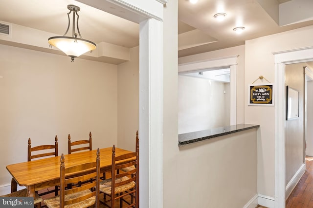 dining room featuring wood finished floors and baseboards