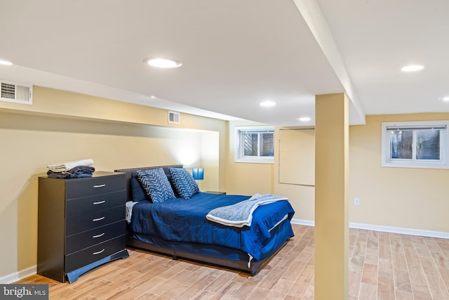 bedroom featuring wood finish floors, visible vents, and baseboards