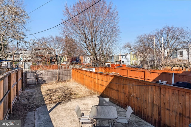 view of yard with a patio area, a fenced backyard, and a residential view