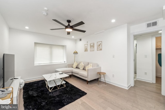 living area featuring baseboards, light wood-type flooring, visible vents, and recessed lighting