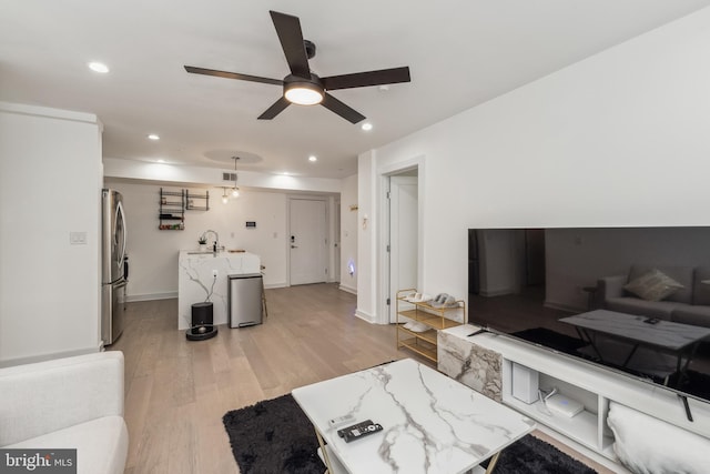 living area featuring light wood finished floors, recessed lighting, visible vents, a ceiling fan, and baseboards