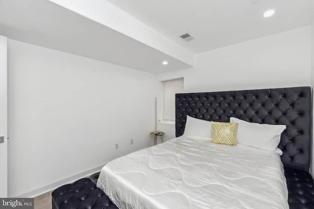 bedroom featuring baseboards, wood finished floors, visible vents, and recessed lighting