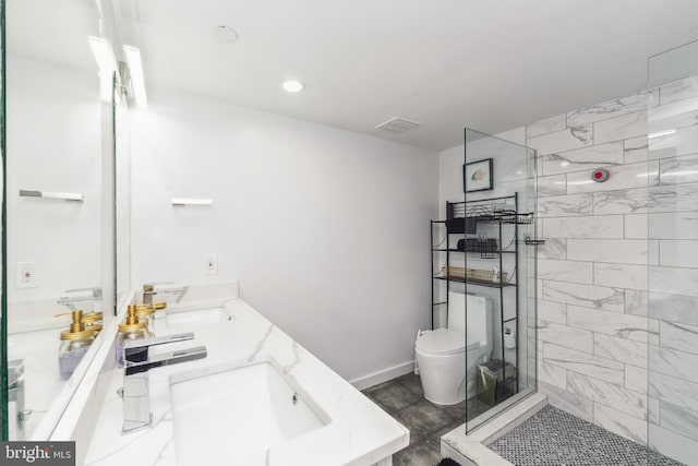 bathroom with a walk in shower, double vanity, a sink, and toilet