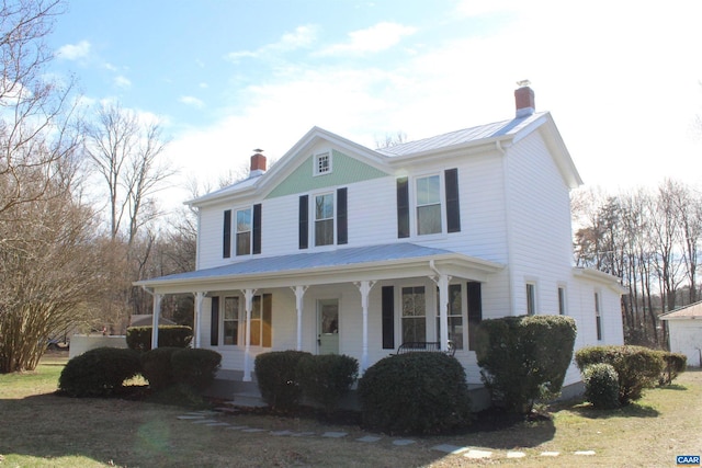 view of front of house featuring covered porch, metal roof, and a chimney