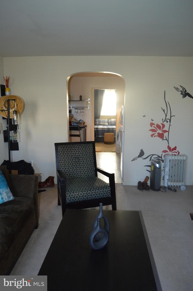 living room with radiator, carpet, and arched walkways