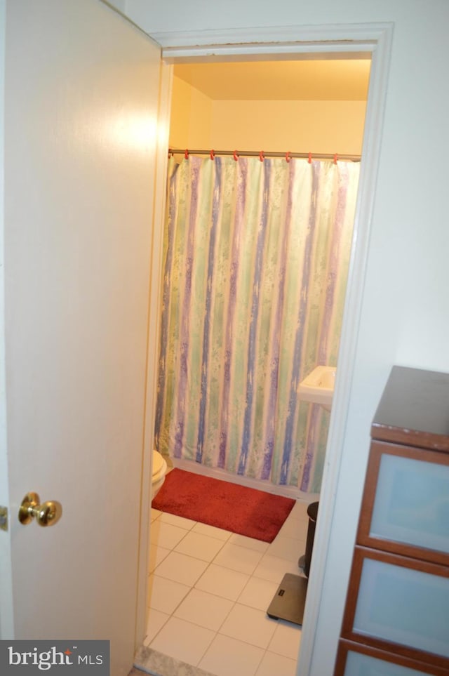 bathroom with a shower with shower curtain, toilet, and tile patterned floors