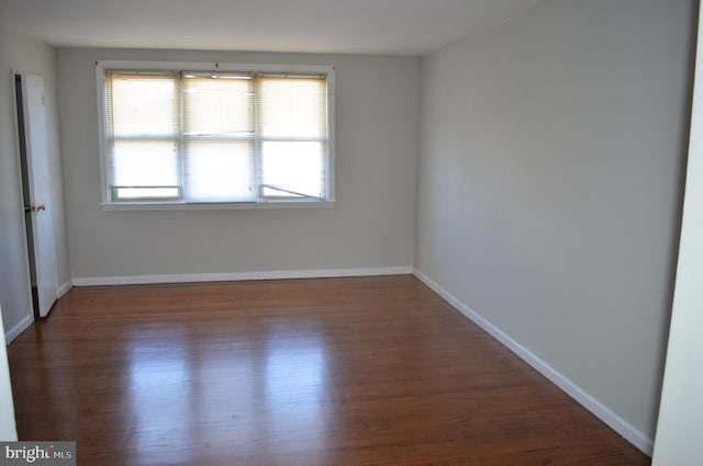 empty room with baseboards and wood finished floors