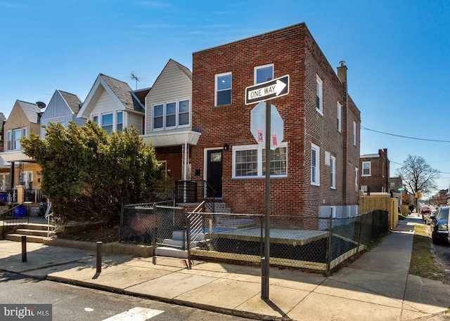 view of property with a fenced front yard and brick siding