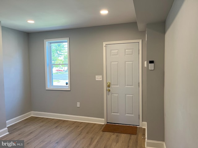 foyer entrance with baseboards, wood finished floors, and recessed lighting