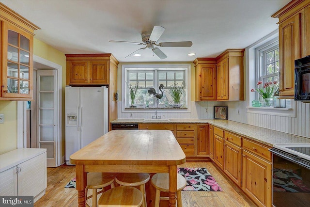 kitchen featuring white appliances, light wood-style flooring, light countertops, and a sink