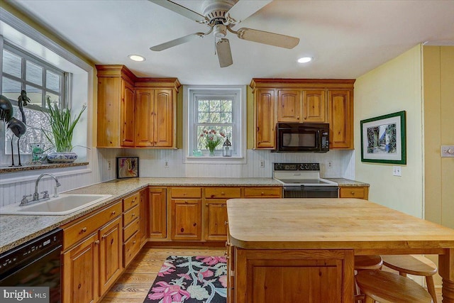 kitchen with light wood-style flooring, butcher block countertops, a sink, decorative backsplash, and black appliances